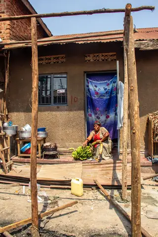 Woman working with matooke outside her home