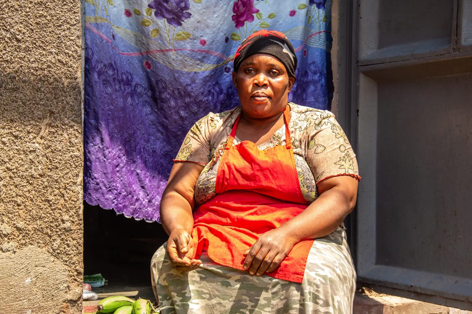 Woman seated in a doorway in her community