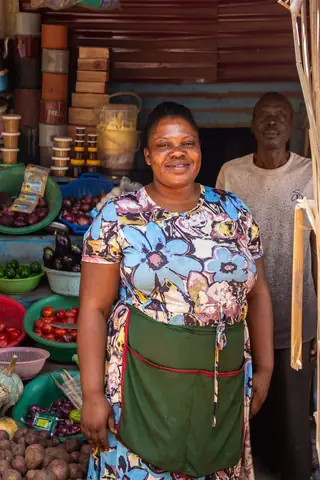 Woman entrepreneur smiling at her market stall in the community