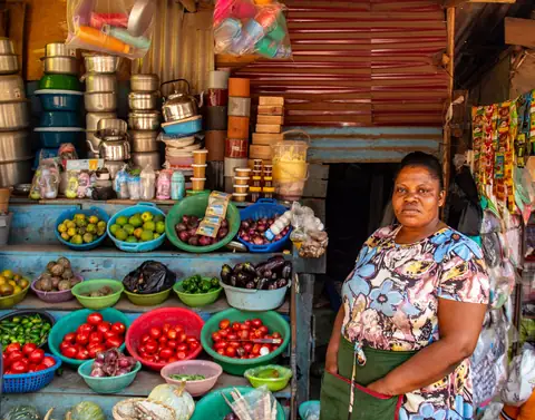Woman entrepreneur standing proudly beside her produce stall